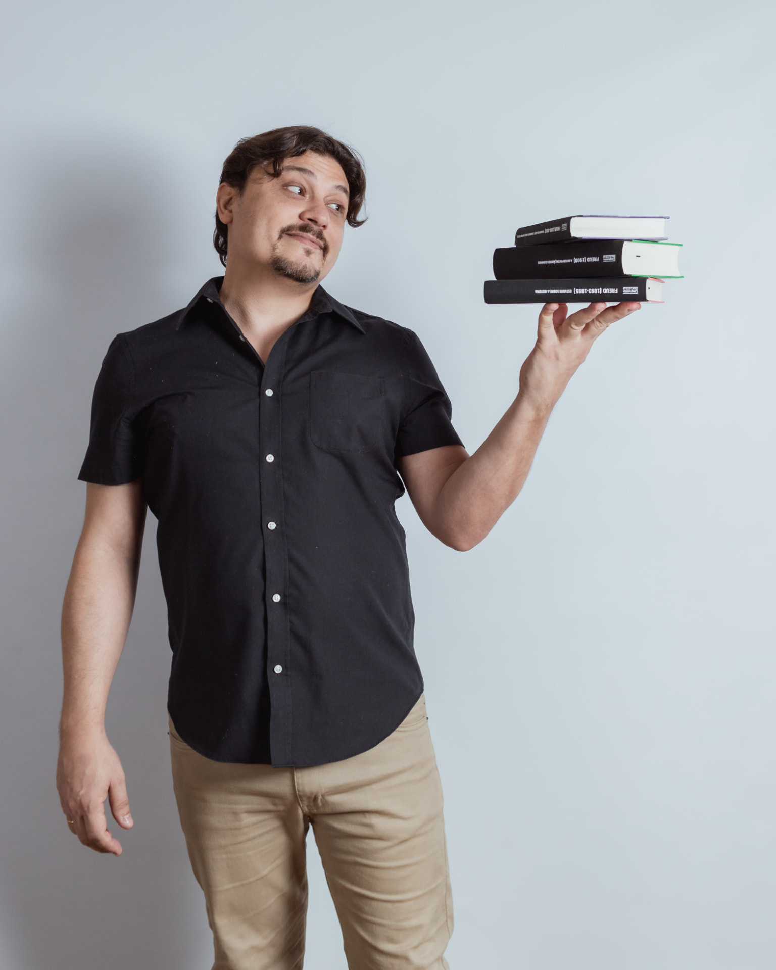 Guilherme Carvalho, psicólogo, segurando livros de psicanálise
